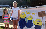 Maddie & Ellie Pedone standing next to their logo for the Snapper Derby